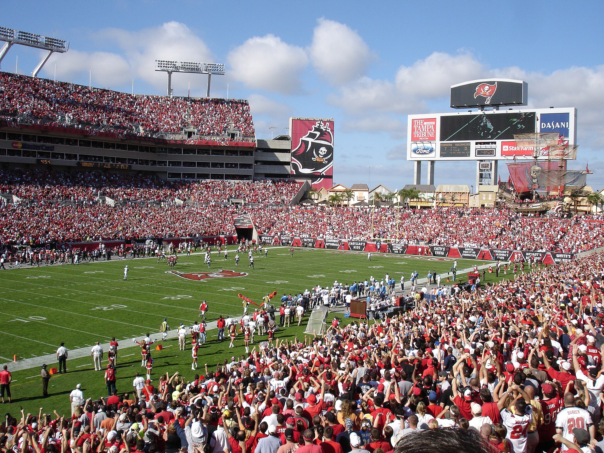 A packed Raymond James Stadium during a Tampa Bay Buccaneers game, with the pirate ship of Buccaneer Cove beyond the end zone