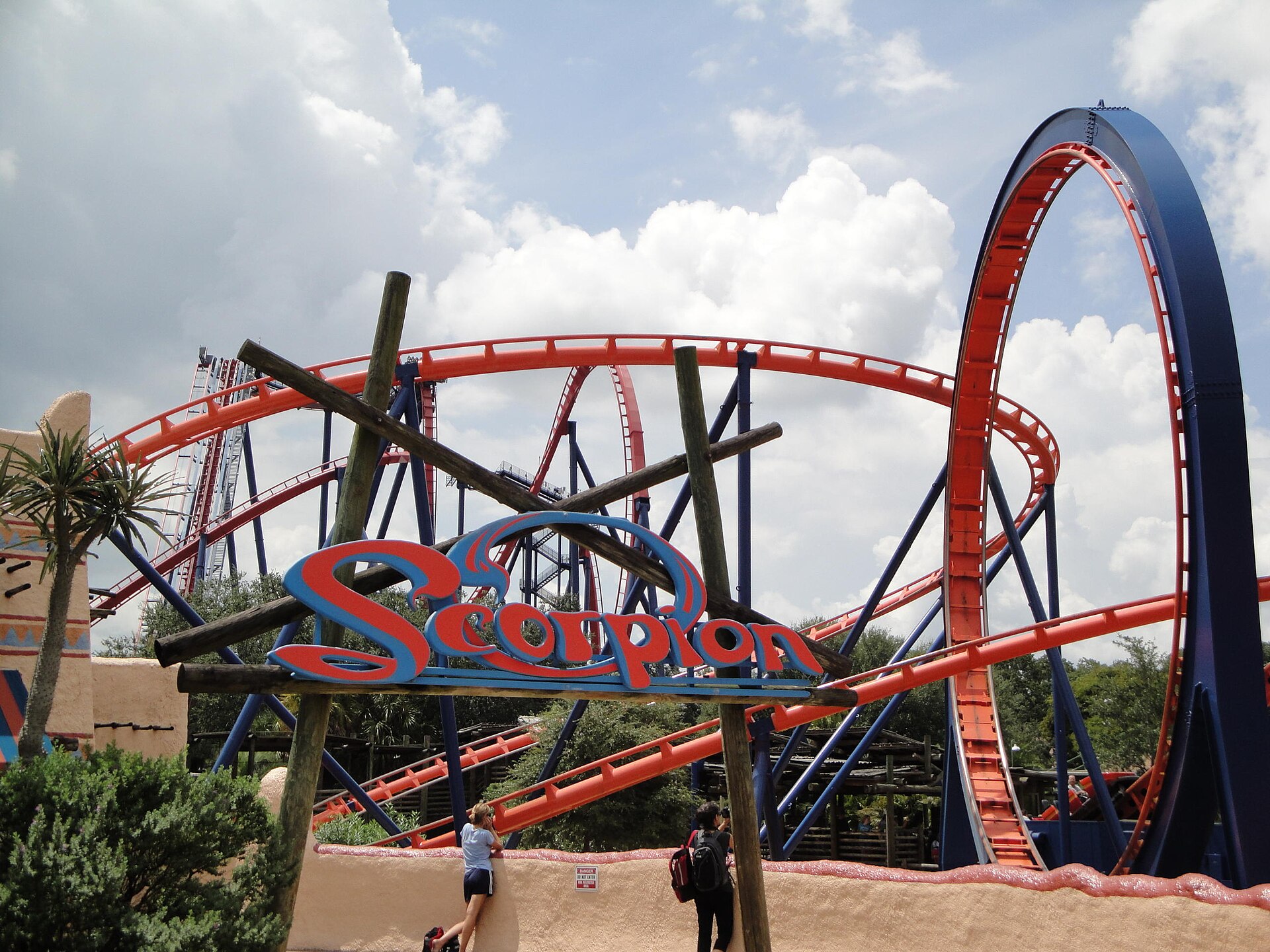 The red and blue track of the Scorpion roller coaster behind its sign at Busch Gardens Tampa Bay