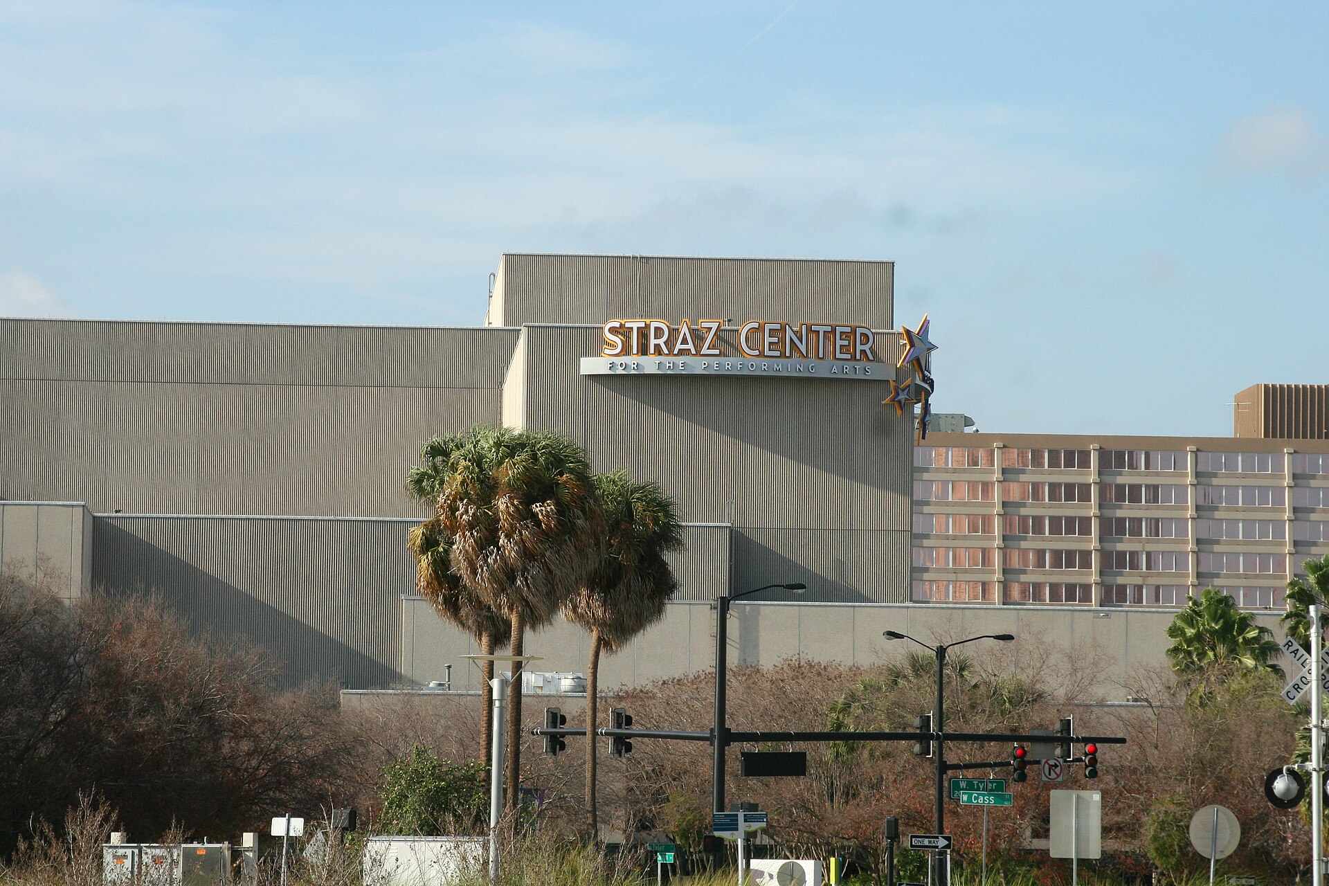 The exterior of the Straz Center for the Performing Arts in Tampa, with its illuminated name sign and star ornament above the building, palm trees in front